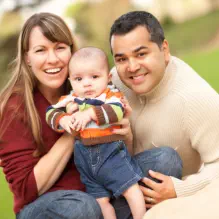 Happy family with baby outdoors