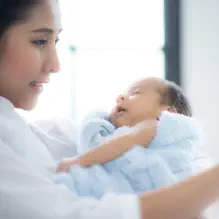 Mother holding baby and smartphone