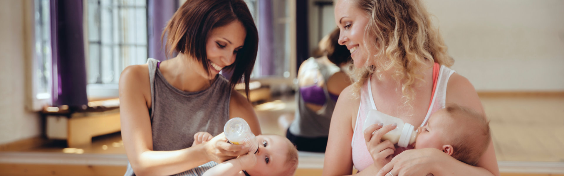 Two mothers feeding their babies