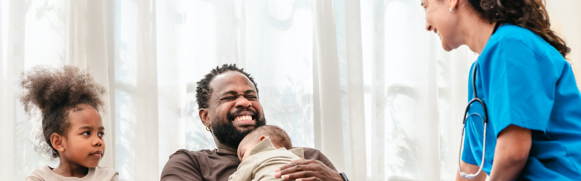 Family with nurse smiling indoors